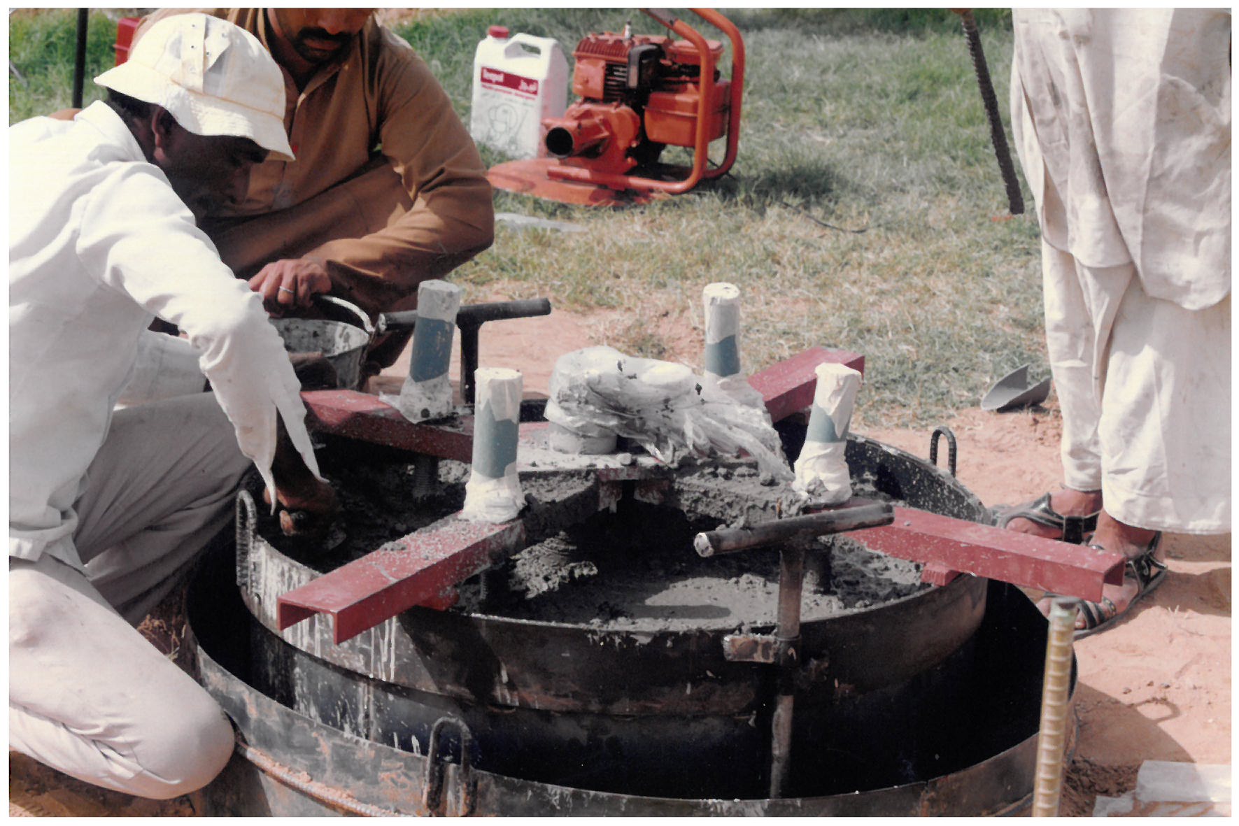 Workers preparing concrete foundation for lighting poles, 1991